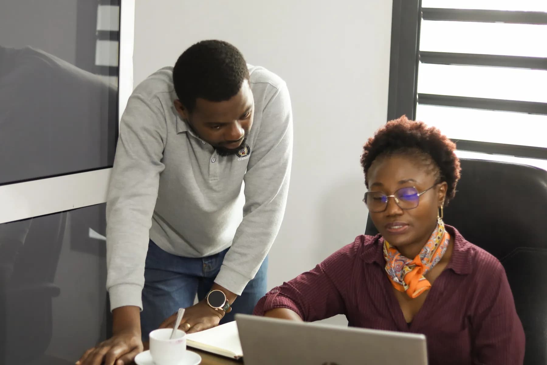 Un formateur Rx Lab accompagne une participante devant son ordinateur pendant un atelier.